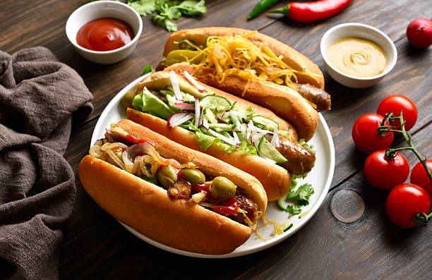 istock Hot dogs with different toppings on wooden table 2243402635