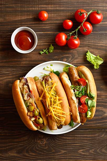 istock Hot dogs with different toppings on wooden background 2243402636