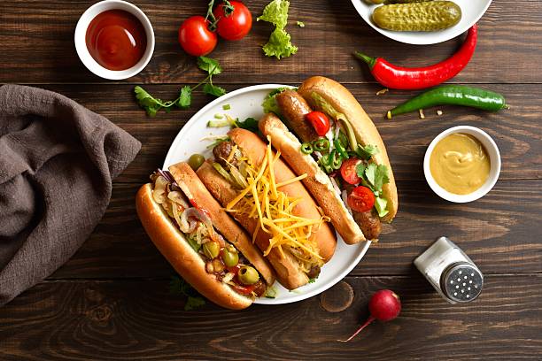 istock Hot dogs with different toppings on wooden background 2243402638