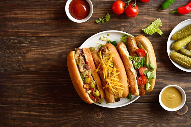 istock Hot dogs with different toppings on wooden background 2243402640