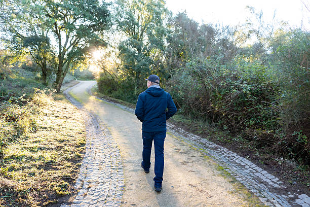 istock Man walking on path in nature at sunset 2243404097