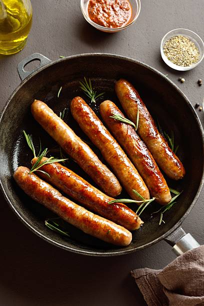 istock Thin sausages in frying pan 2243405863