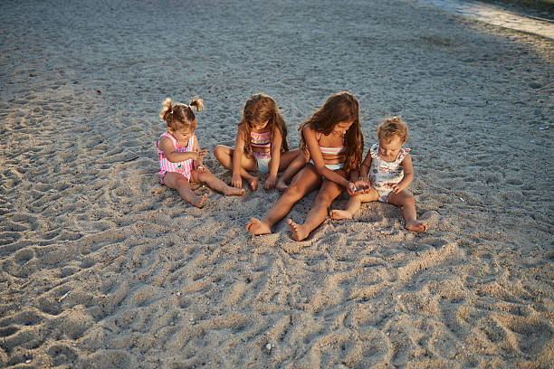istock Girls playing in sand at beach during summer vacation 2243408287