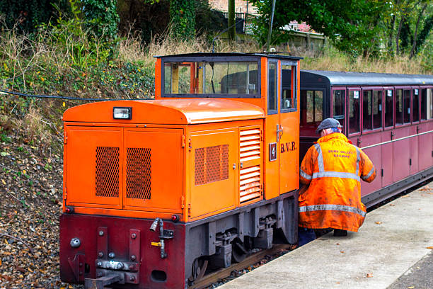 Aylsham, Norfolk, United Kingdom: October 15, 2024: ‘Rusty’, a narrow gauge railway diesel engine which is used for shunting, being coupled with passenger carriages prior to moving them elsewhere. The 15” Bure Valley Railway runs between Aylsham and Wroxham in Norfolk, Eastern England; it uses steam, electric and diesel engines and stops at Brampton, Buxton and Coltishall on its way to Wroxham in the heart of the Norfolk Broads. The Bure Valley Railway opened in 1990 and has been a popular tourist attraction ever since.
