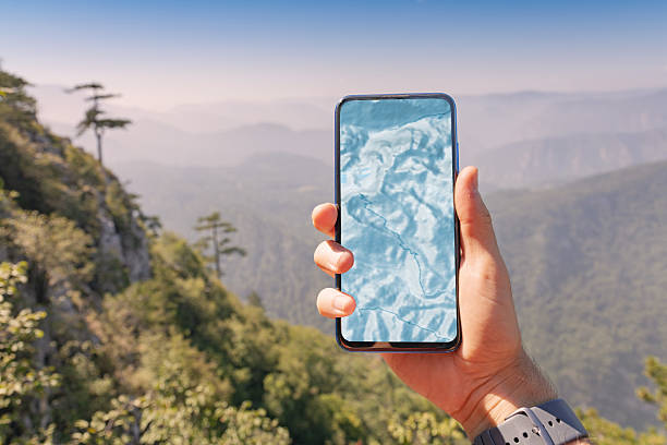 istock Hand holding a smartphone displaying a topographic map, navigating outdoor mountains and green forest. Exploring nature with technology 2243412373