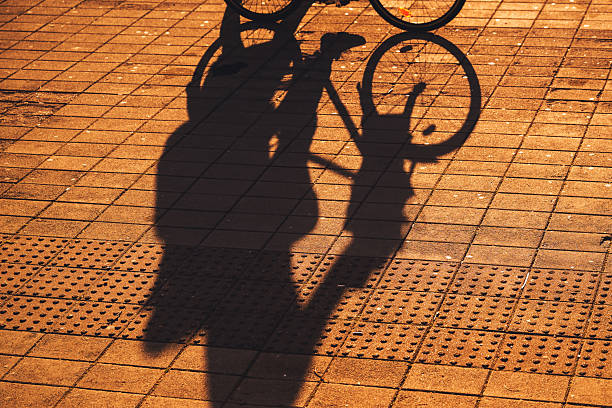 Germany, Berlin, Zehlendorf, May 16, 2024 - Bicycle wheel with wheel shadow on street