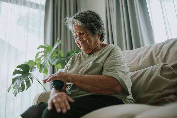 istock Elderly massaging her forearm with a spiky massage ball. 2243422499