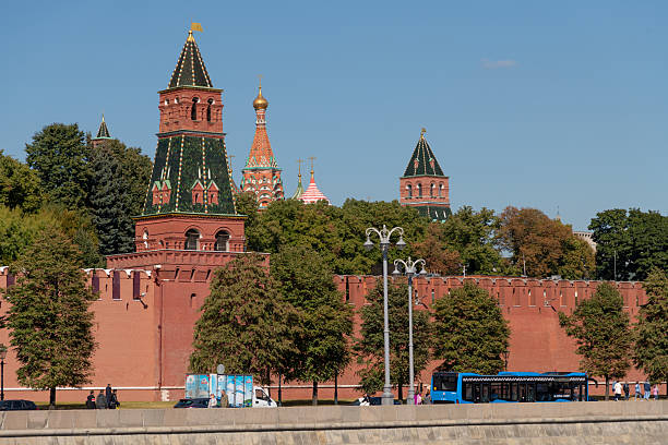 Russia, Moscow - September 10, 2022: In Moscow, Russia, the view showcases the iconic red walls of the Kremlin standing tall against a clear blue sky. The vibrant domes of St. Basil's Cathedral are visible in the background.