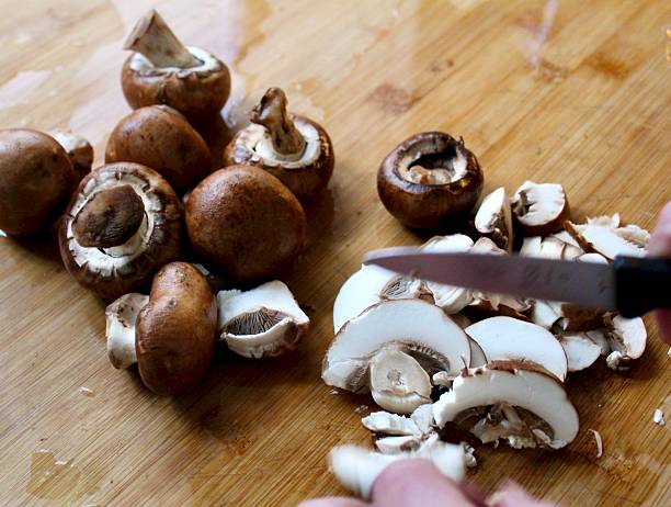 istock Hands chopping Chestnut mushroom - close-up 2243437859