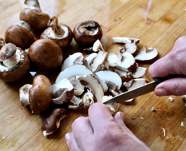istock Hands chopping Chestnut mushroom - close-up 2243437883