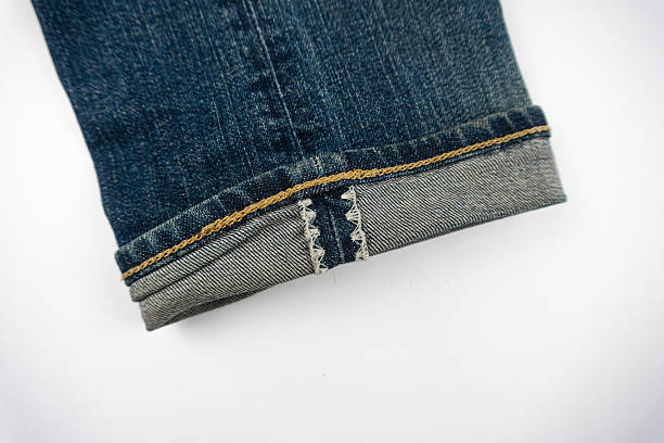 istock Close-up of denim jeans cuff with visible stitching and folded hem 2243443831