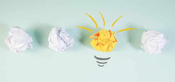 istock crumpled paper ball with light bulb and heart on white background. idea concept 2243444185