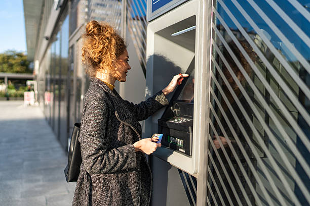istock Woman doing a transaction at an atm machine 2243444392