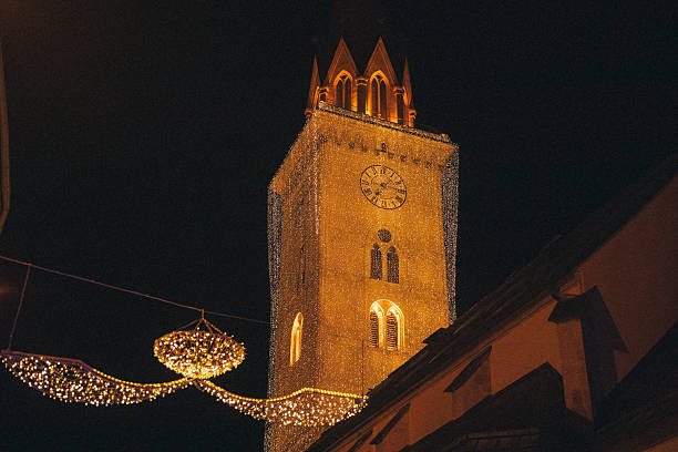 Villach, Austria - November 17, 2023: Advent opening ceremony showcases a beautifully lit clock tower surrounded by festive decorations and a charming ambiance