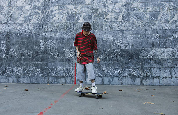 Young skater glides calmly along a stone wall in a relaxed street ride