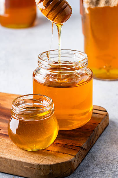 istock Honey jar and honey dipper on vintage background 2243445826