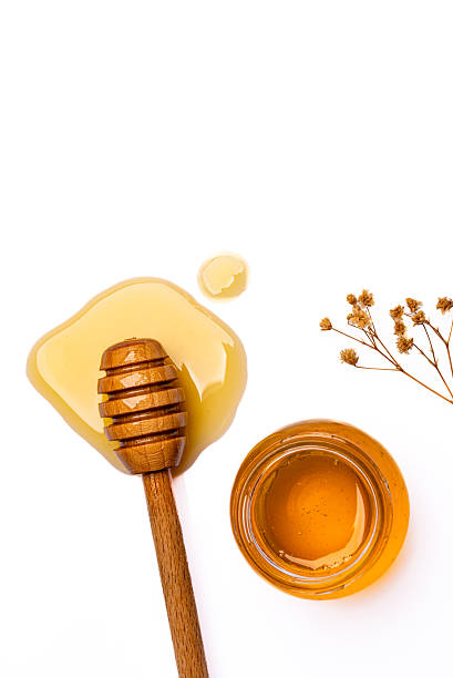 istock Honey jar and honey dipper on white background 2243445889