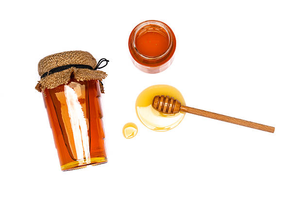 istock Honey jar and honey dipper on white background 2243445927