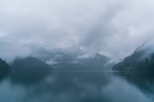Alpine green lake. Clouds float over the lake. Soft focus.