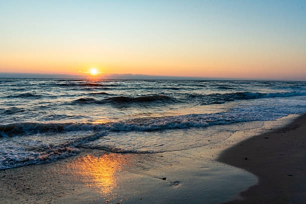 istock Sunset over the sea with gentle waves on the beach 2243450599