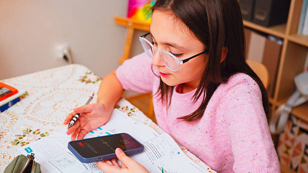 istock Little Girl Using Smartphone AI to Solve Homework Problem at Home 2243454463