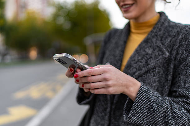 istock Woman texting on smartphone outdoors in urban setting 2243454826