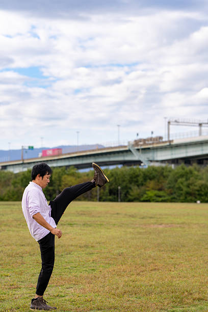 Man Performing a High-Leg Stretch | Dynamic Warm-up Outdoors