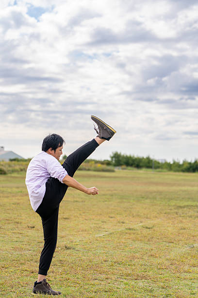 Man Performing a High-Leg Stretch | Dynamic Warm-up Outdoors