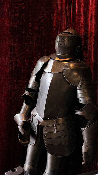 istock Medieval Knight’s Armor with Closed Helmet Leaning Against a Red Curtain 2243455612