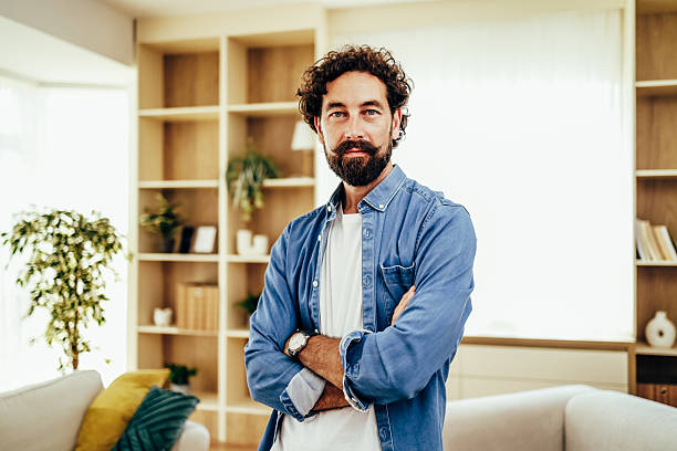 istock Confident man with beard and mustache in home living room 2243458351