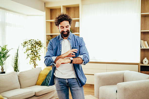istock Man checking watch in living room, waiting for time 2243458355