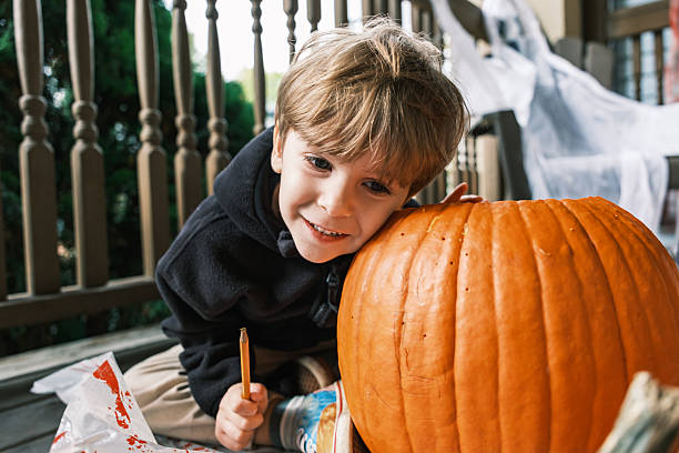 istock Young boy sketching on pumpkin for Halloween 2243458672