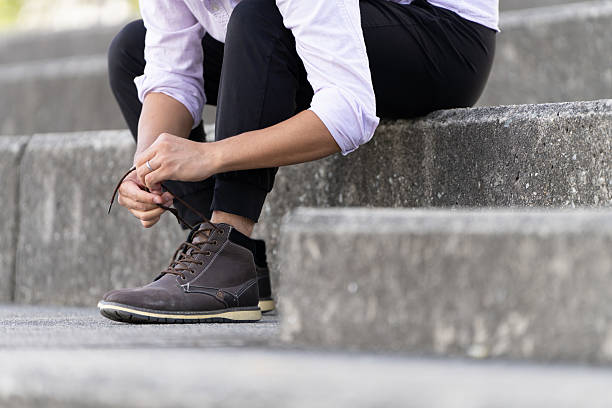 Man Sitting on Steps Tying His Shoelaces