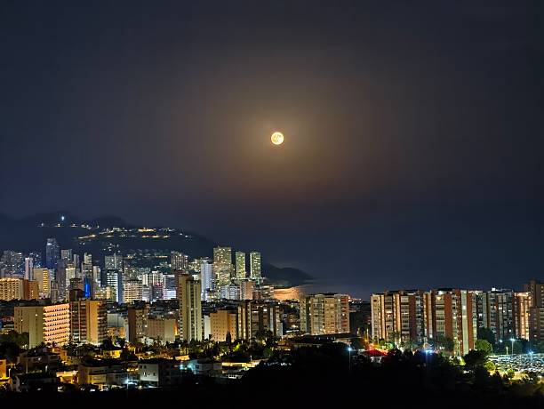 istock Evening scene featuring glowing buildings and distant mountain 2243459025