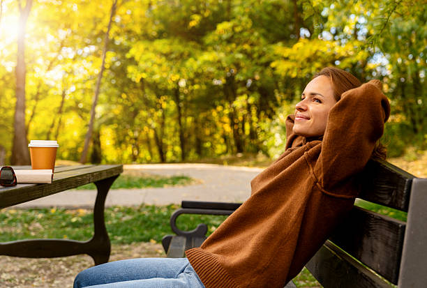istock Woman relaxing in autumn park during weekend 2243460117