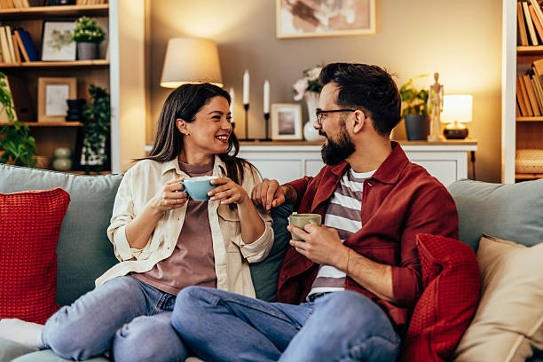 istock Couple relaxing on sofa at home drinking coffee 2243460442