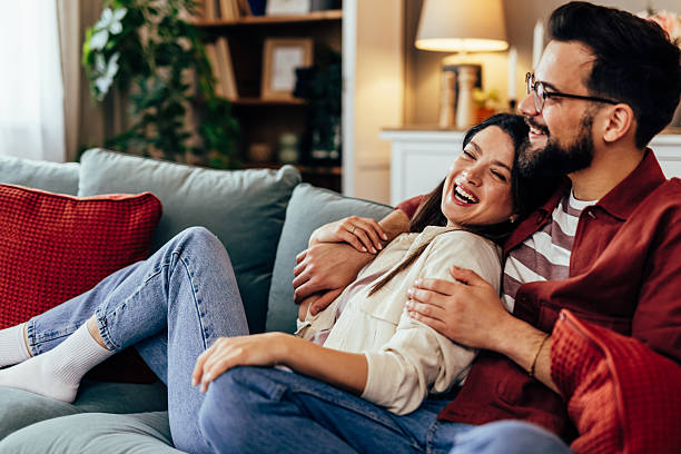 istock Happy young couple laughing relaxing on sofa 2243460556
