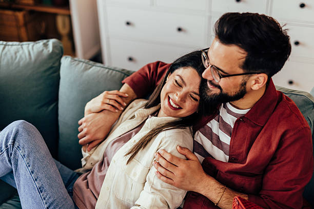 istock Happy couple embracing on a sofa at home 2243460557