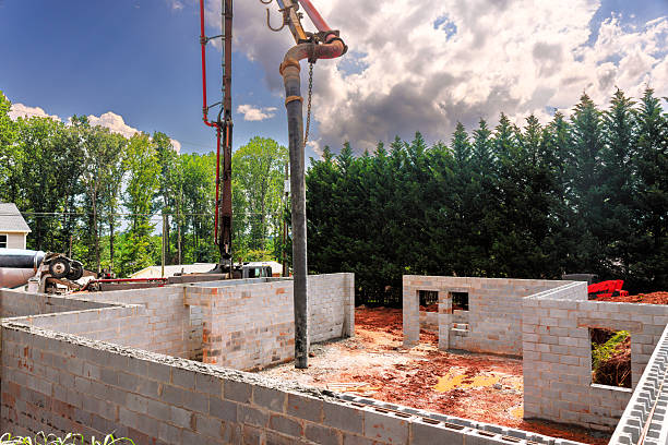 istock Construction site where concrete is being poured into cinder block walls 2243461959