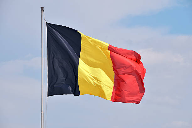 istock Belgian flag flying high on a flagpole against blue sky 2243464098