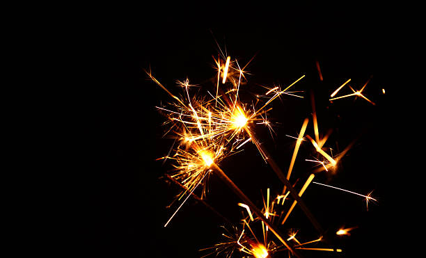 istock Golden sparklers showering bright sparks at night 2243464253