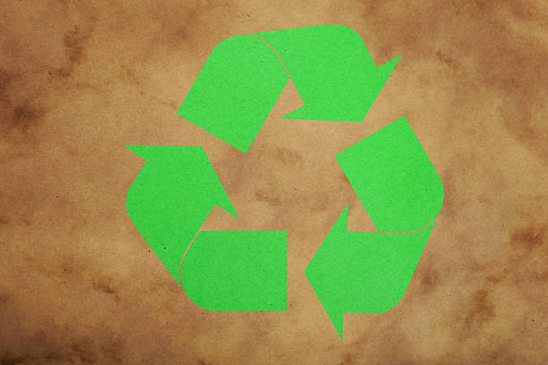 istock Green recycling symbol on brown paper background 2243464290