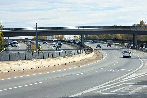 istock A wide, curving highway intersection with multiple lanes and traffic passing beneath a large concrete overpass structure - M0 ring in Budapest 2243479554
