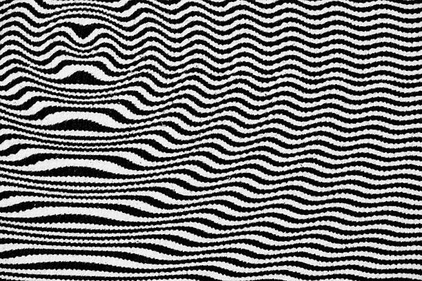 Extreme close-up of wavy black lines printed on white paper, forming a distorted, high-contrast pattern with rhythmic curves and optical flow.