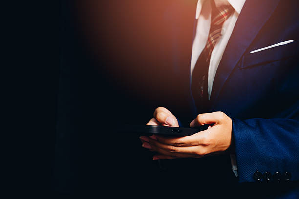 istock Professional businessman using smartphone in dark environment, demonstrating communication, technology, and modern lifestyle 2243483676