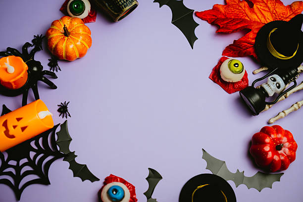 istock Festive Halloween Decorations with Pumpkins, Candles, and Spooky Elements on Purple Background for Seasonal Celebrations 2243484947