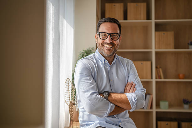 istock Confident businessman standing with arms crossed in office 2243485189