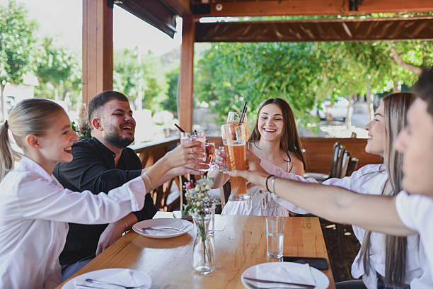 istock Friends Toasting Drinks At Outdoor Dining Table, Laughter And Sunshine During Summer Get-Together 2243485355