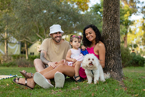 istock Family sitting on the grass with poodle 2243487076