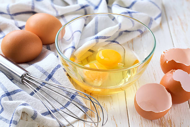 istock Breakfast preparation. Omelet recipe.  Whisk raw eggs in a bowl on a white table. 2243487103